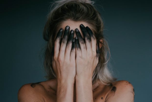 a woman covering her face with her hands