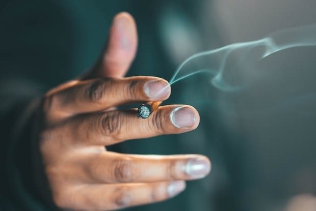 a hand holding a cigarette