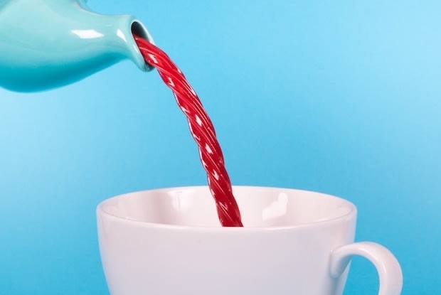 a teacup pouring licorice into a cup