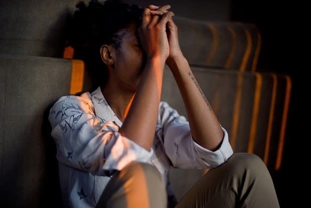 a woman looking distressed, sitting on the ground