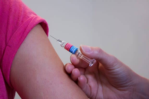 A girl being vaccinated with a syringe