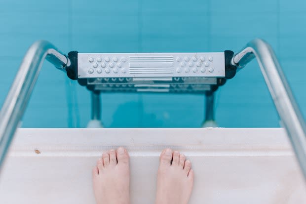 a person standing in front of a pool ladder