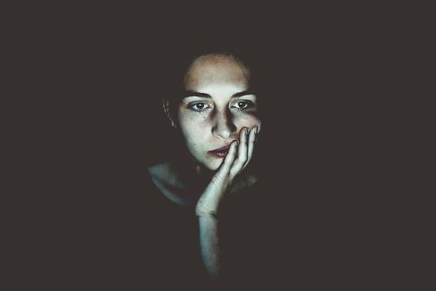 a woman in a dark room looking concerned