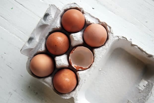 six eggs in a carton with one cracked egg