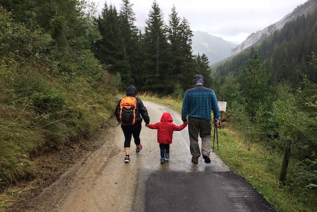 a family of three hiking a trail