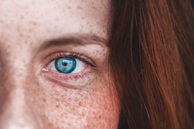 a close up of a woman’s blue eye