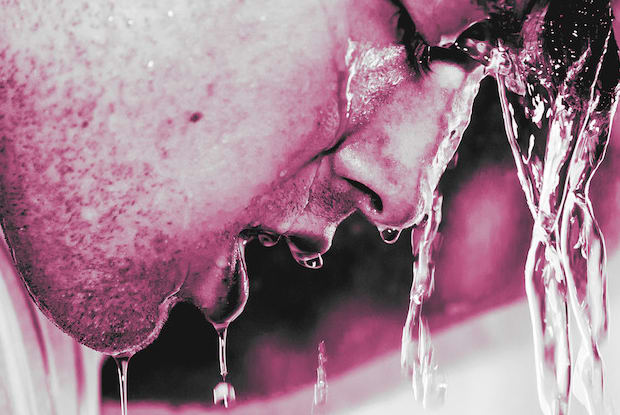 a man washing his face with warm water