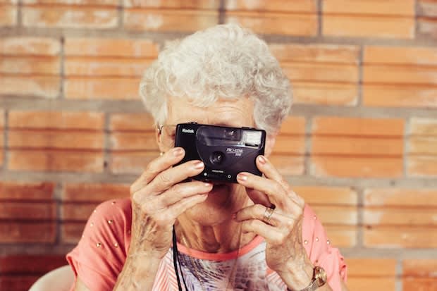 an older woman looking through a camera