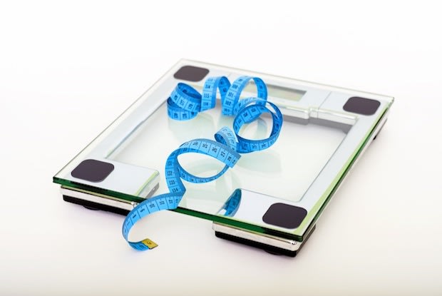 A tape measure lying on top of a weight scale