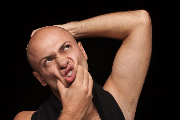 a bald man scrunching his face in frustration