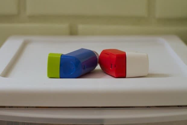 two inhalers on a white surface