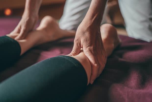 a person massaging another person’s calves