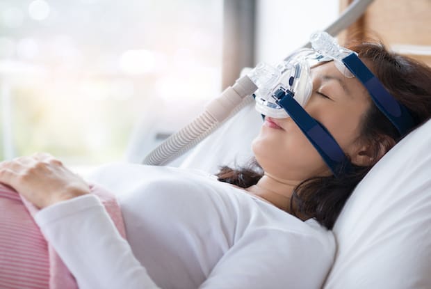 a woman sleeping with a CPAP