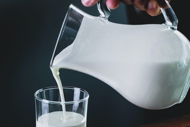 a pitcher pouring milk into a glass