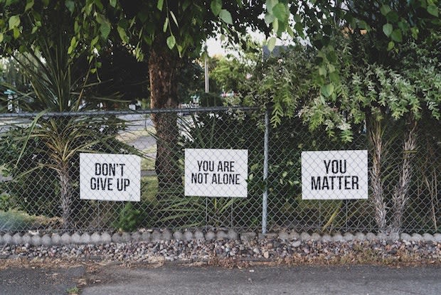 three encouraging signs on a fence