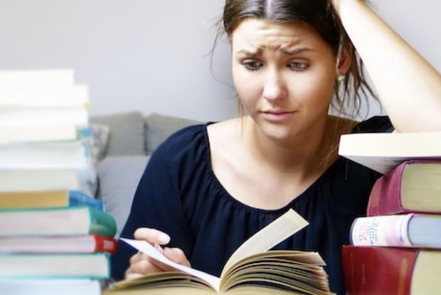 A woman studying while surrounded by books