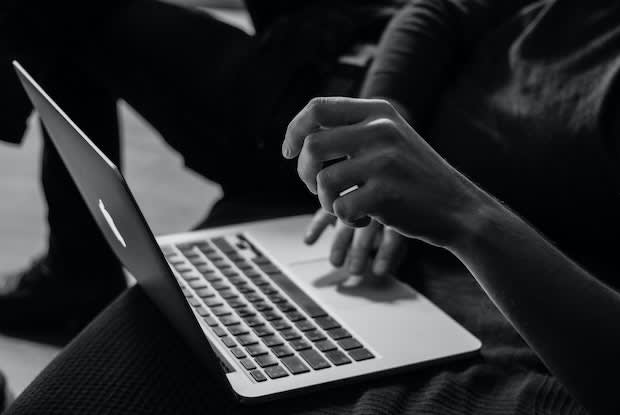 a black and white image of someone on their laptop