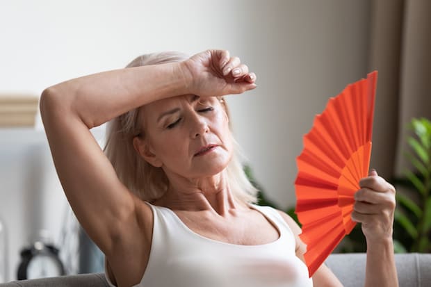 A woman fanning herself in her house