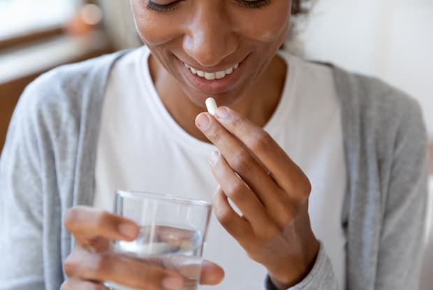 a woman taking a pill