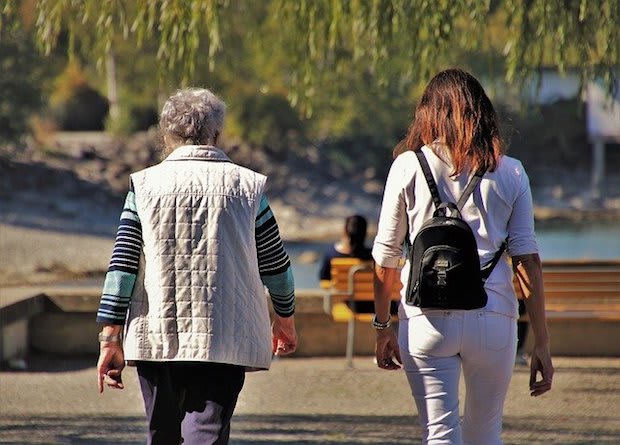 an older woman walking with a younger woman outside