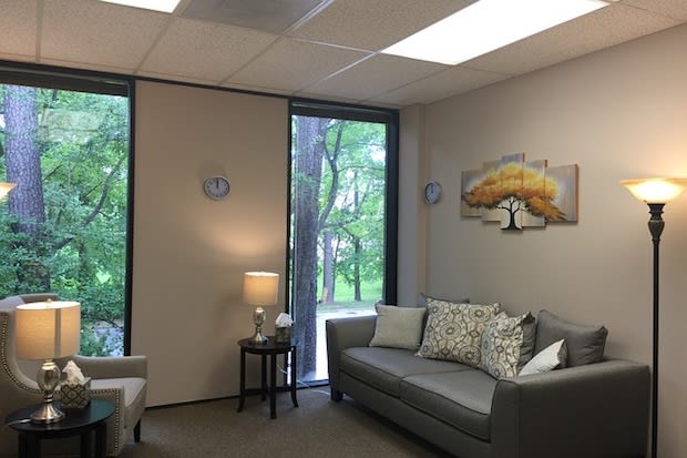 a psychiatrist’s office with a sofa and chair