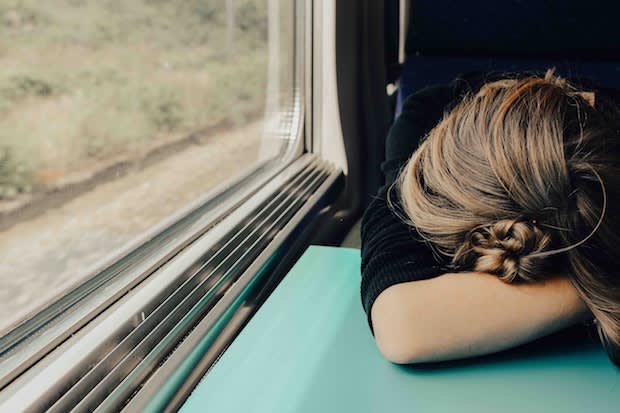 a woman laying her head down on a train table