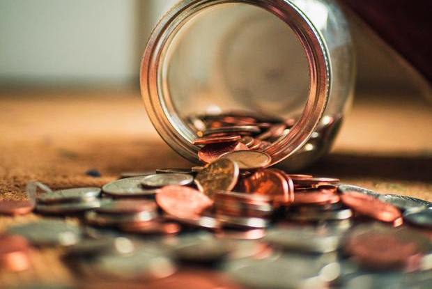 Jar turned over with coins spilling out