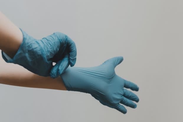 a set of hands wearing rubber gloves