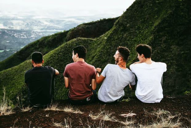 a group of men sitting on top of a hill