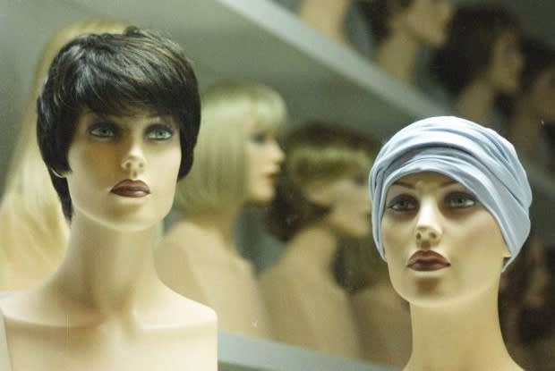 a vintage photograph of a shelf of wigs