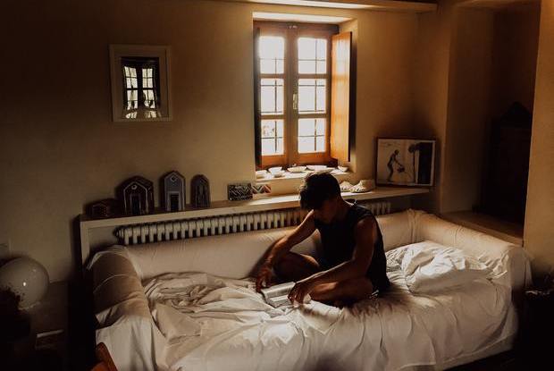 a man sitting on his bed