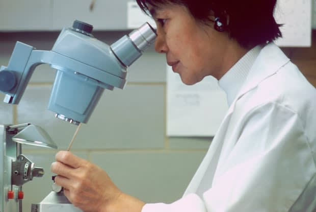 a woman looking in a microscope