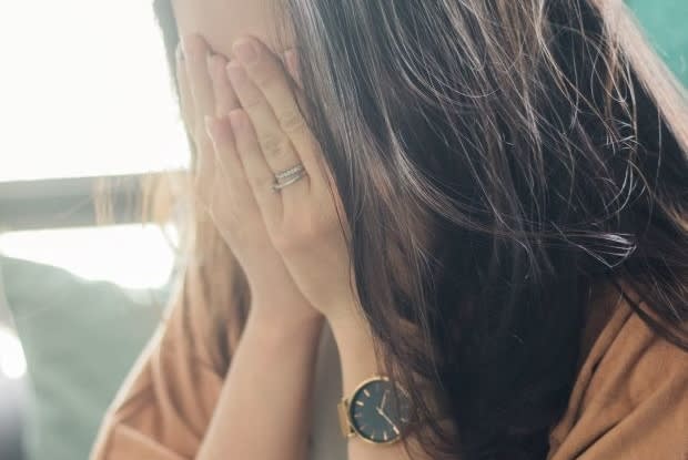 a woman with her head in her hands, showing distress