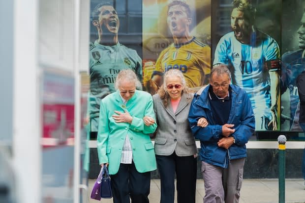 three older people standing arm in arm