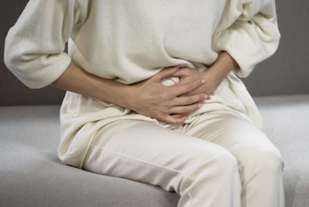 a woman grasping her stomach in pain