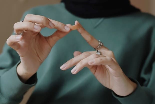 a woman applying a bandage to her finger