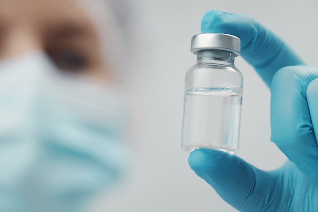 a doctor holding a vial of medication