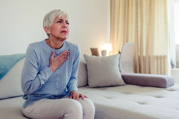 a woman clutching her chest in pain