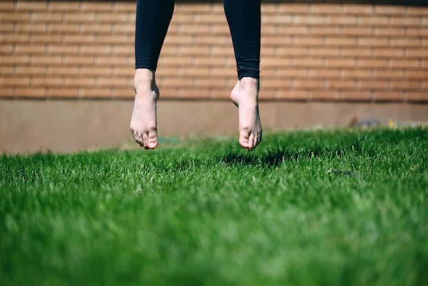 a person wearing compression stockings, jumping on a grass field