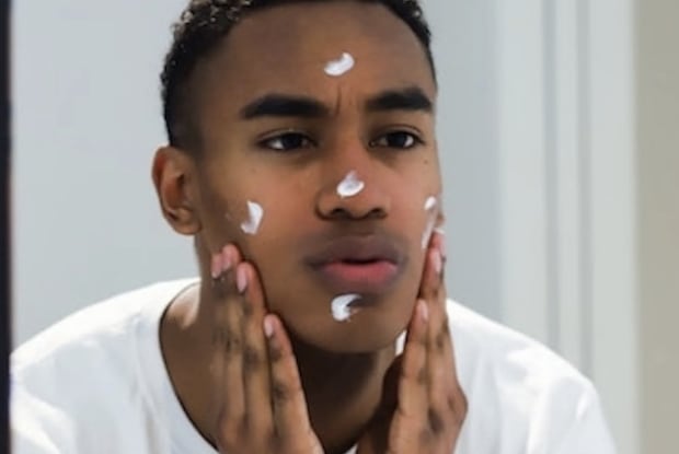 a man moisturizing his face