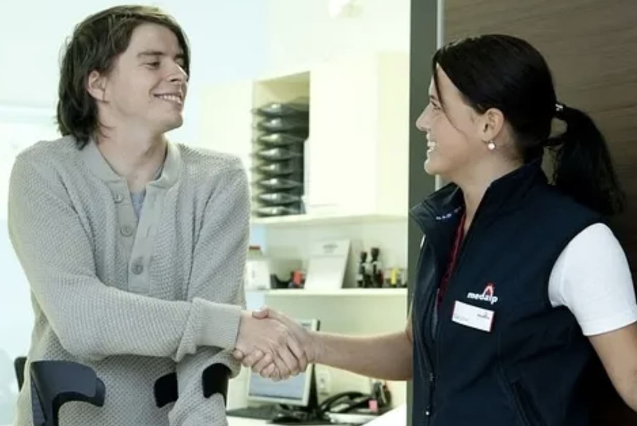 a woman helping a person with crutches