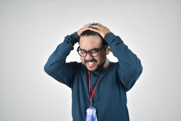 a stressed man pulling at his hair