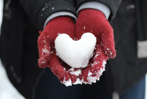 someone holding a snow heart in their hands