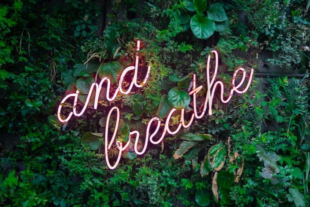 a neon sign that says breathe