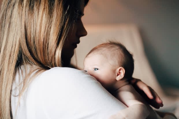 a woman holding a newborn baby