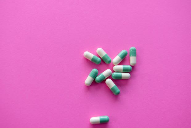 white and green pills on a purple background