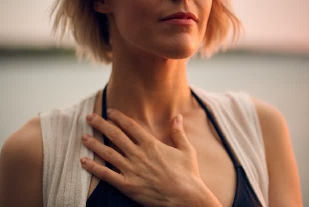 a woman with her hand on her chest
