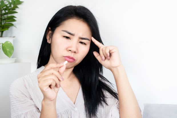 confused woman looking at Entresto tablet