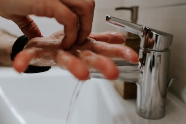 A person washing their hands in the sink