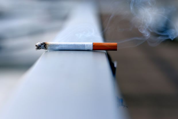 a cigarette on a hand railing